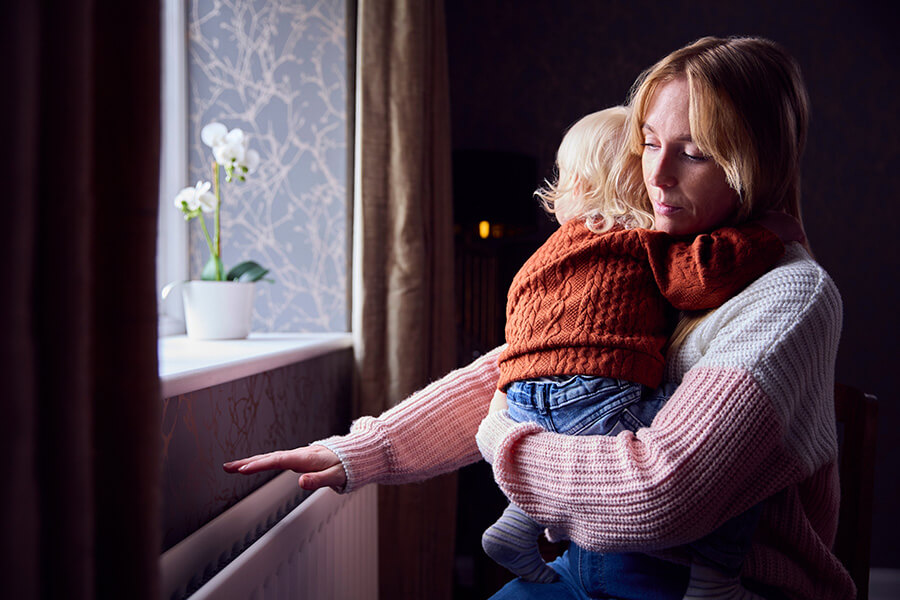 woman holding baby checking heater