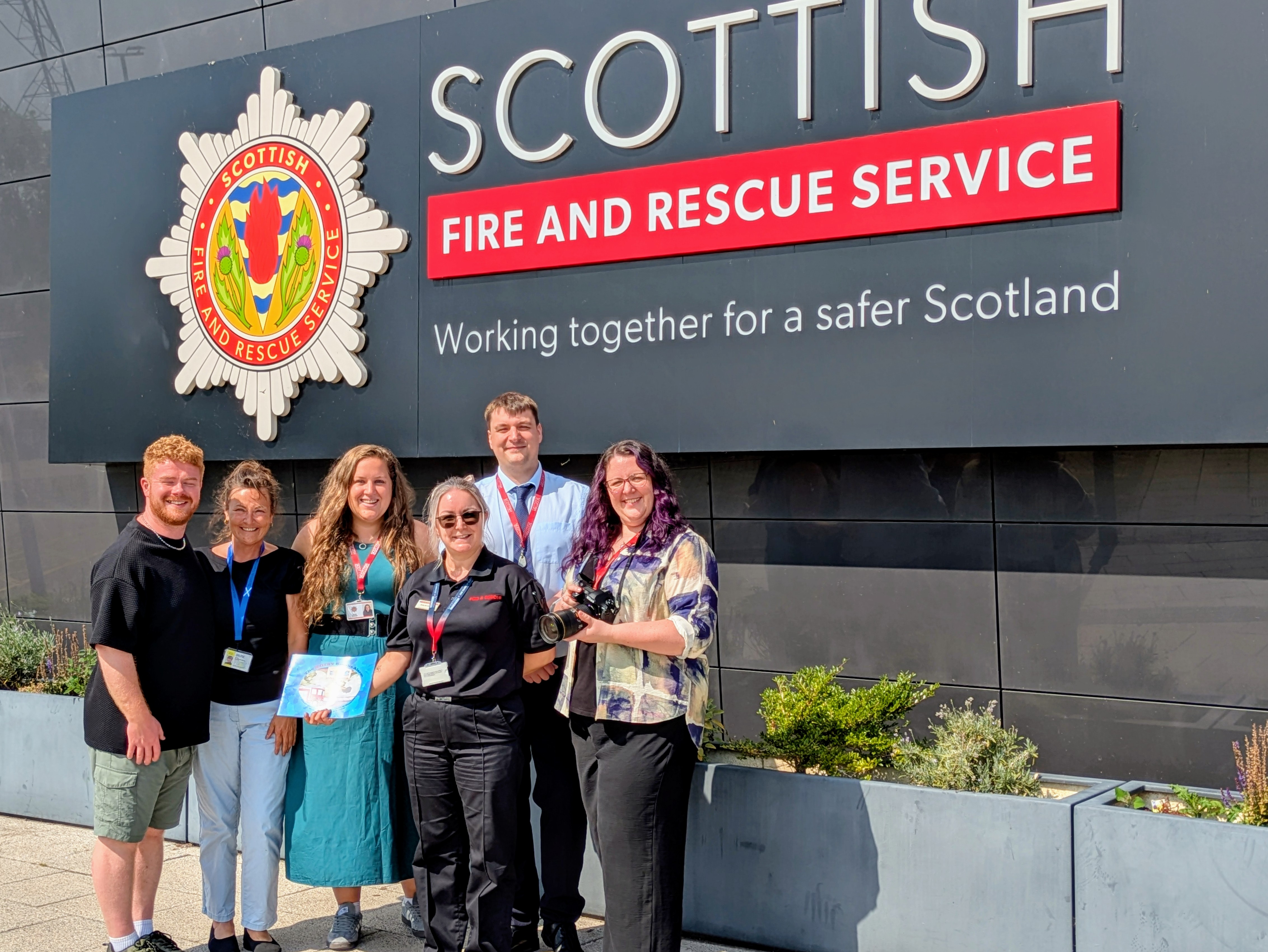 Members of the BSL community take a photo in front of the Scottish Fire and Rescue Service building