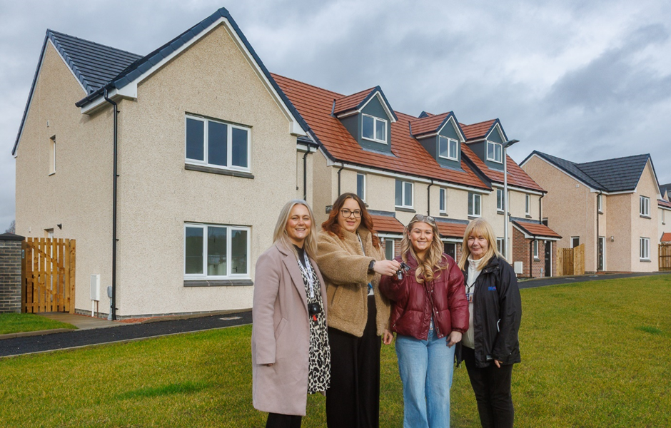 Staff members stand in front of a new build acquisition home